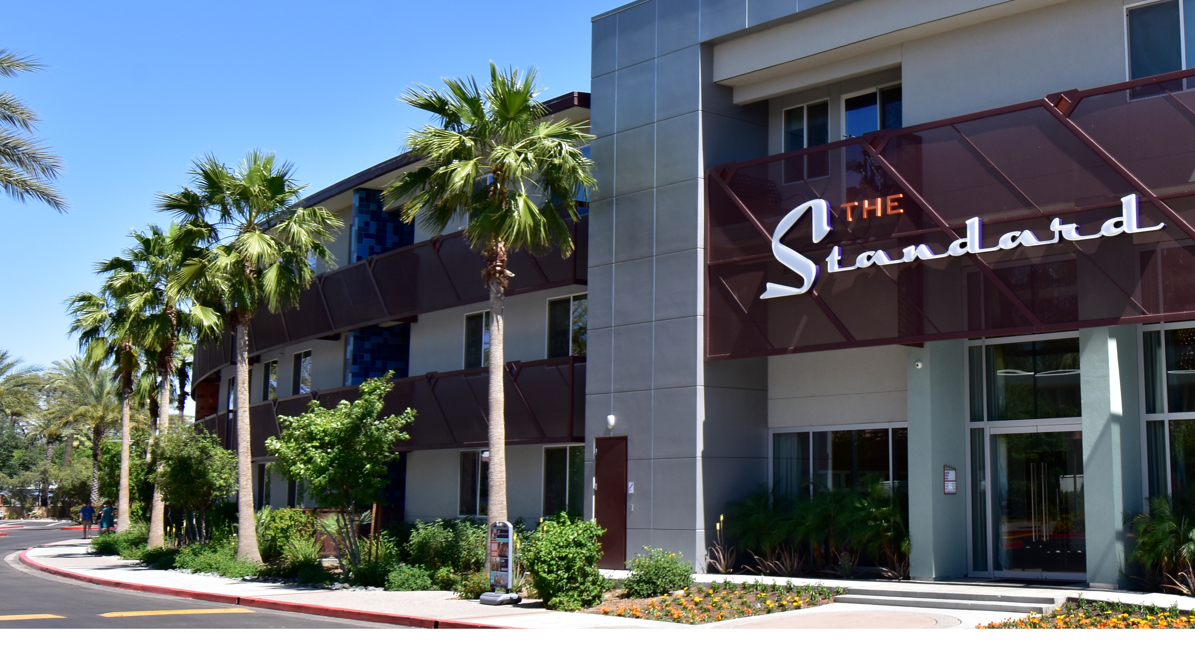 apartment building entry with curved facade palm trees and signage Scottsdale Arizona