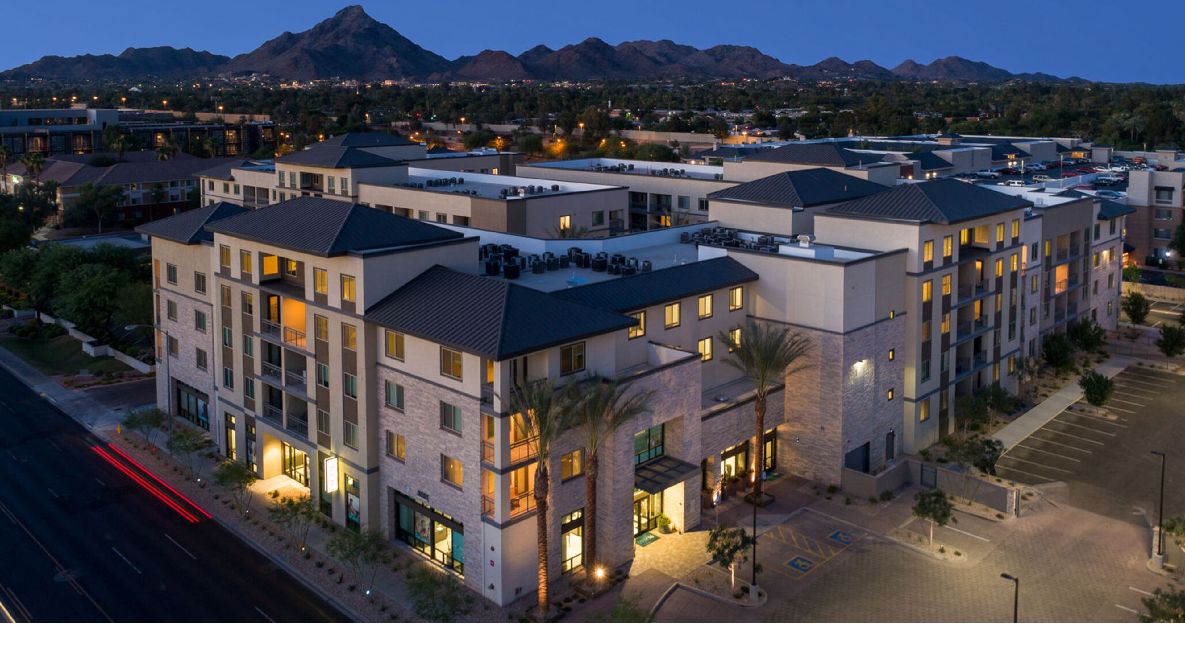 aerial view of Peak 16 Apartments at dusk showing building massing lighting and urban context Phoenix Arizona
